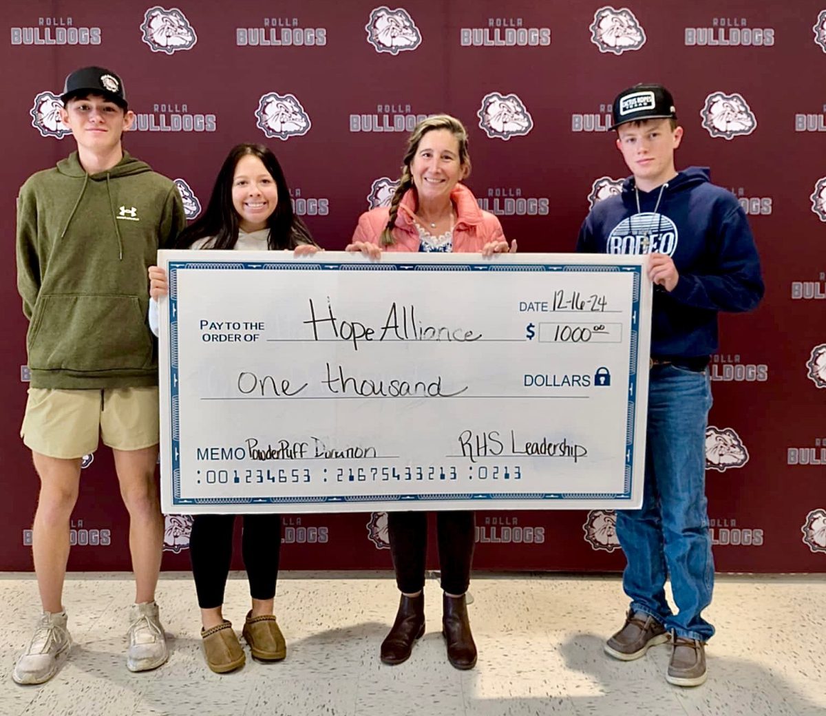 RHS Leadership students Braydon Shenefield, Molly Allison, and Cooper Light present a check for $1000 to Faith Barnes with Hope Alliance. 